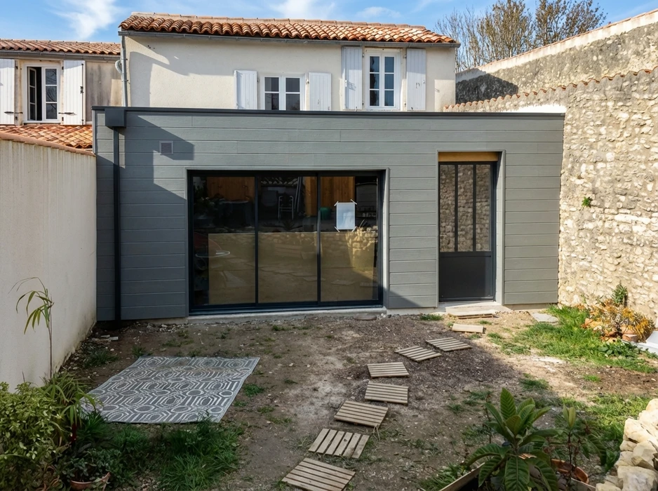 Maison contemporaine à ossature bois avec bardage en lames horizontales, toiture en ardoises grises équipée de fenêtres de toit et panneau solaire thermique