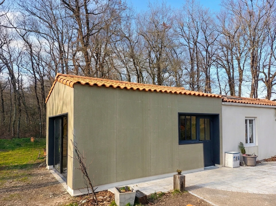 Chantier de construction résidentielle avec architecte ou contremaître en casque blanc et salopette bleue présentant des plans à un couple de clients