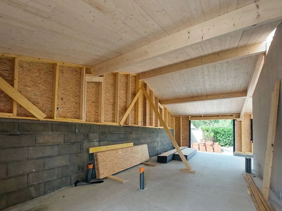 Intérieur résidentiel présentant un parquet en bois endommagé avec soulèvement important de lames au centre de la pièce