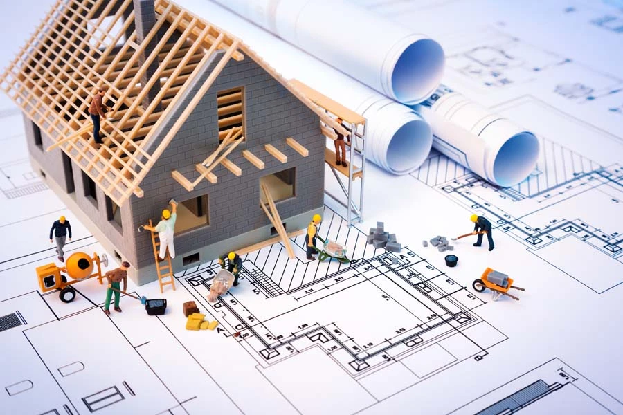 Deux professionnels examinent des plans architecturaux sur une table de travail